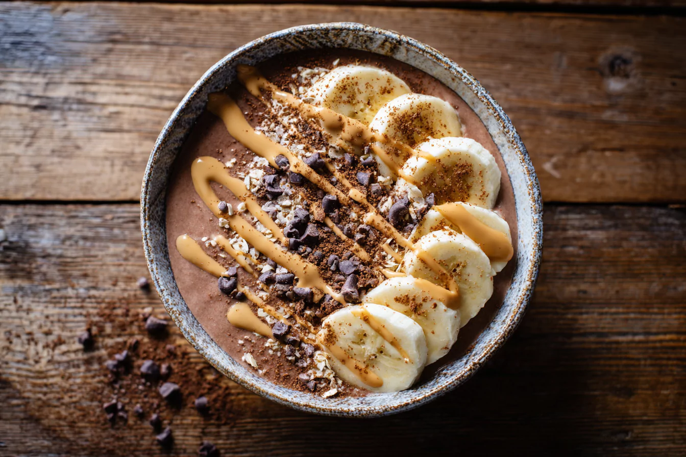 chocolate-peanut-butter-crunch-bowl Chocolate peanut butter yogurt bowl with banana, cacao nibs, and cinnamon.
