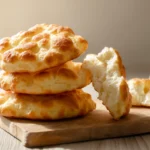 fluffy cottage cheese cloud bread stacked on wooden board