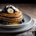 Oat and cottage cheese pancakes with banana and blueberries on a plate